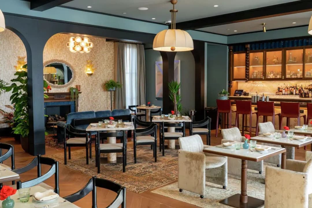 Modern restaurant interior with elegant decor, tables set for dining, and a stylish bar.